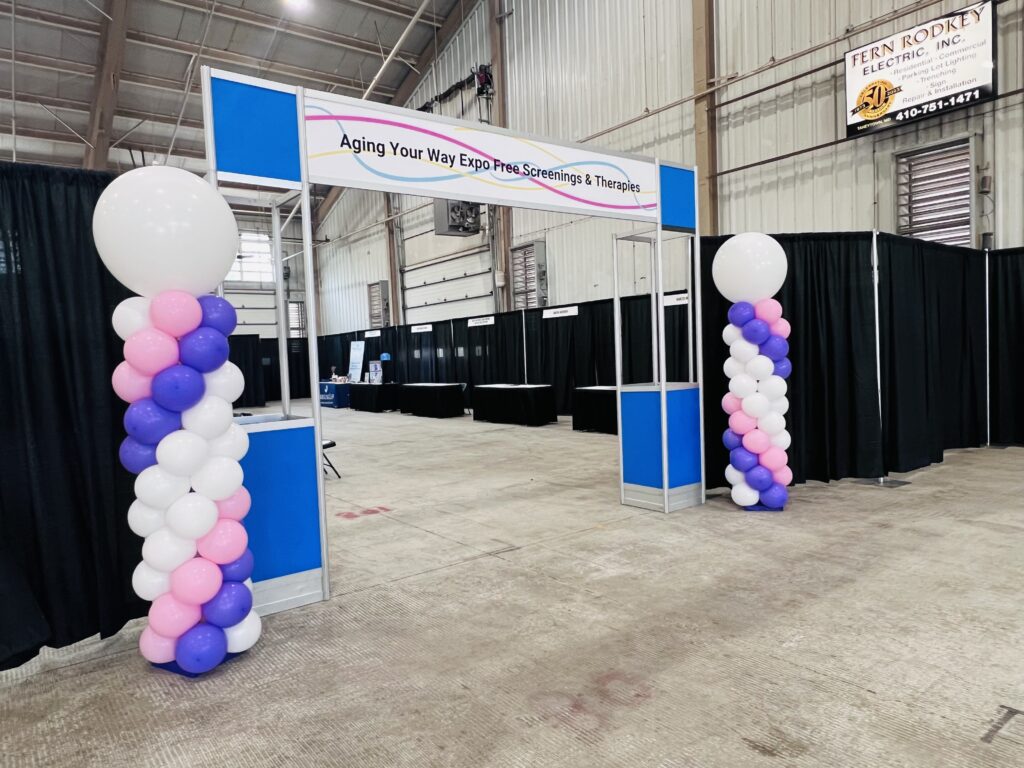 Two 8-foot tall balloon columns in purple, pink, and white for a conference event.