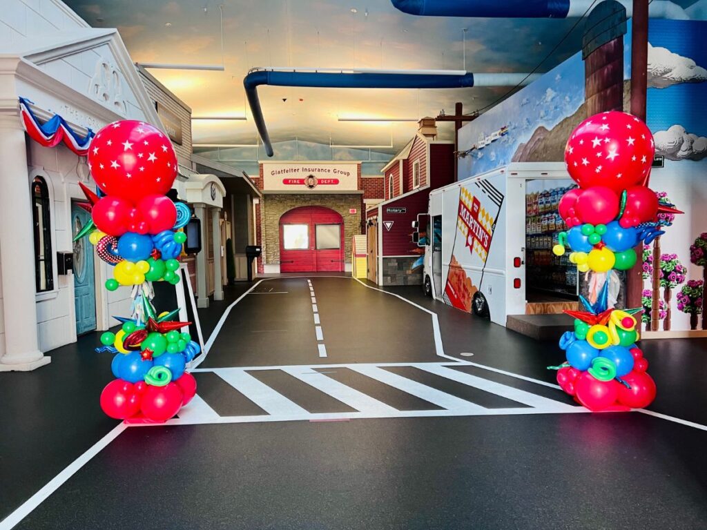 Colorful, whimsical, and fun balloon decor featuring two elaborate balloon columns.